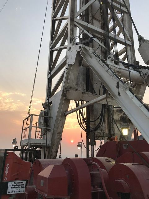 Drilling rig floor equipment and derrick at sunset